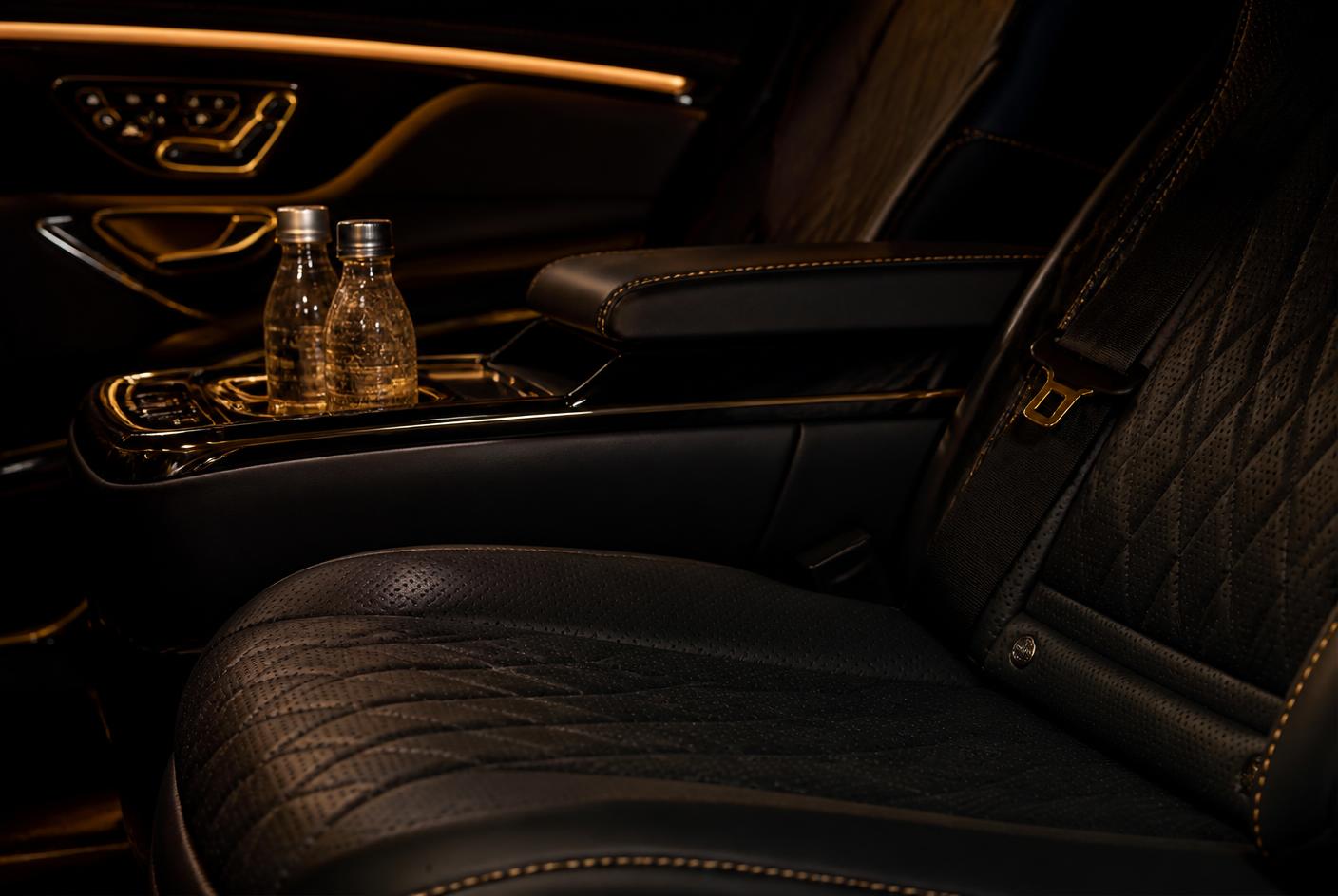 Quilted black leather rear cabin with gold accents and complimentary water